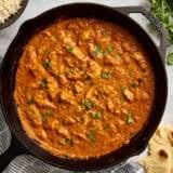Overhead view of a homemade butter chicken in a cast iron skillet.