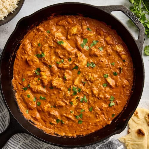 Overhead view of a homemade butter chicken in a cast iron skillet.