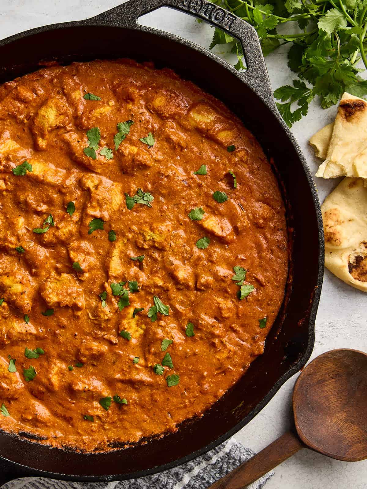 Overhead view of a homemade butter chicken in a cast iron skillet.