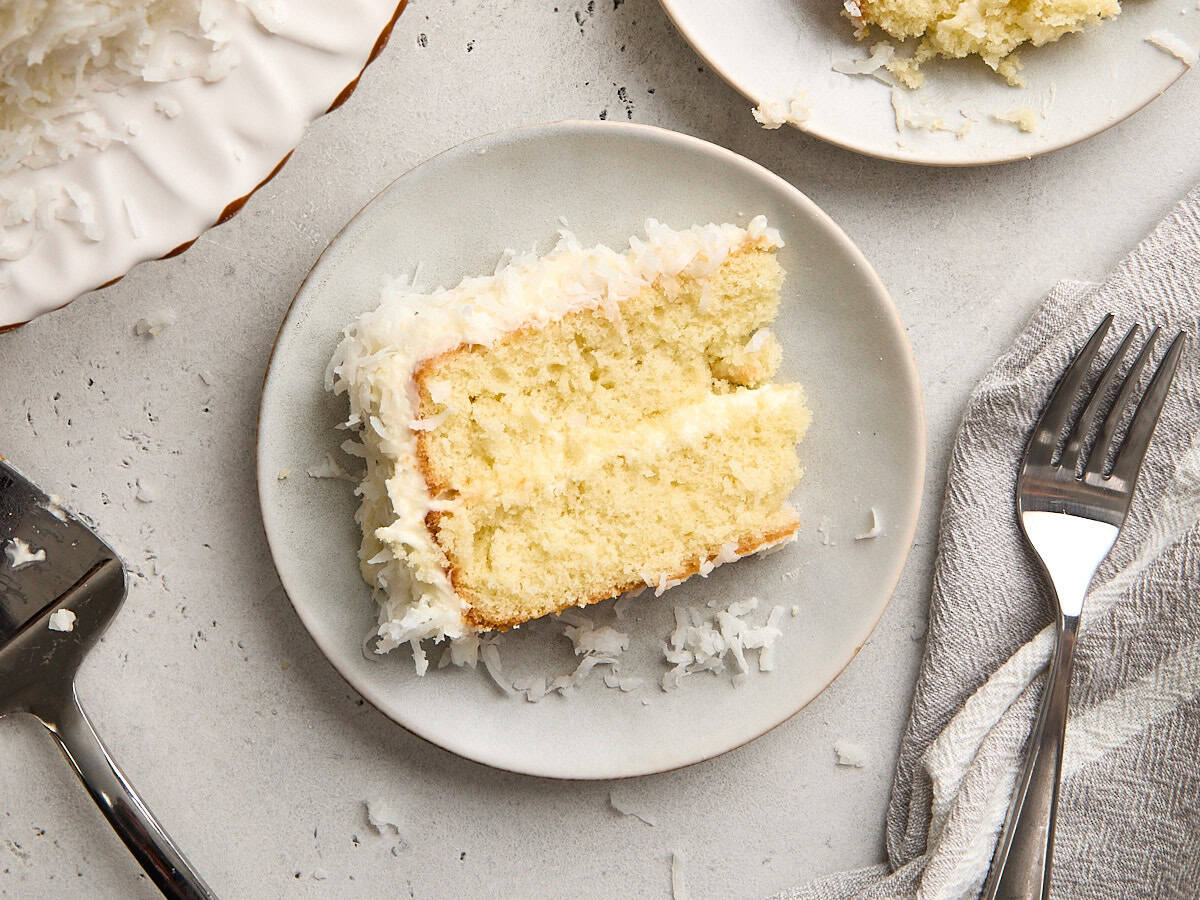 Overhead view of a slice of coconut cake on a plate.