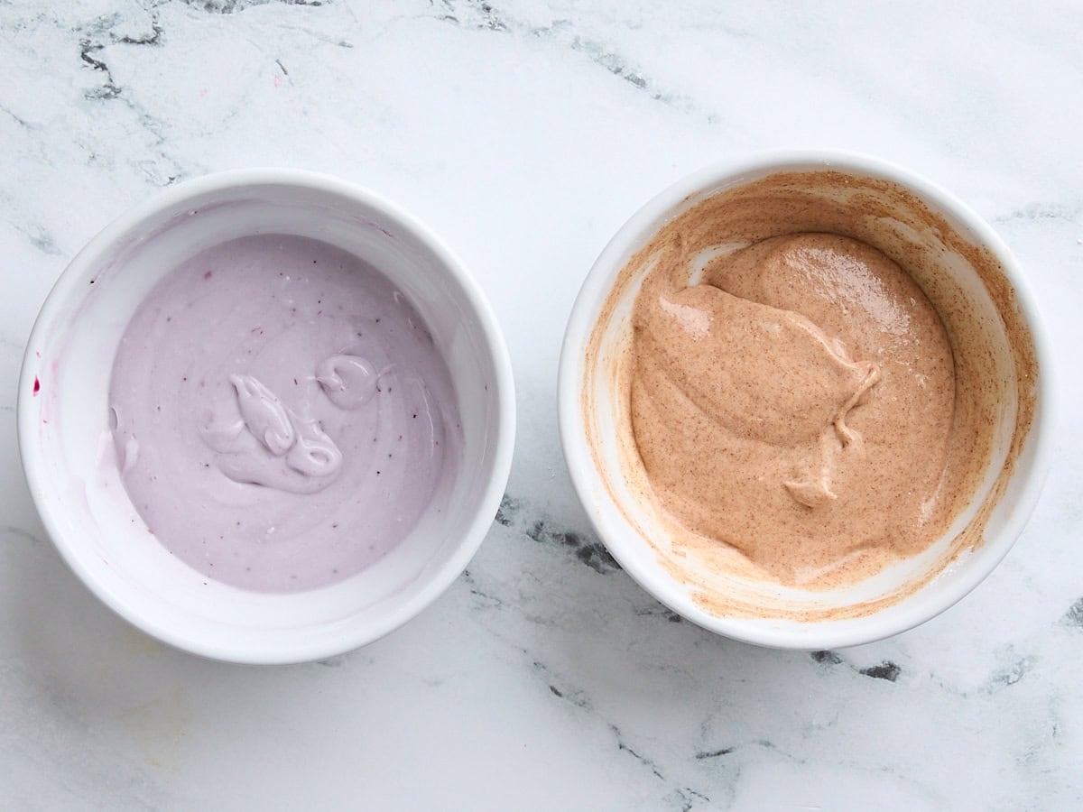Berry frosting in a bowl and cinnamon sugar frosting in a bowl.