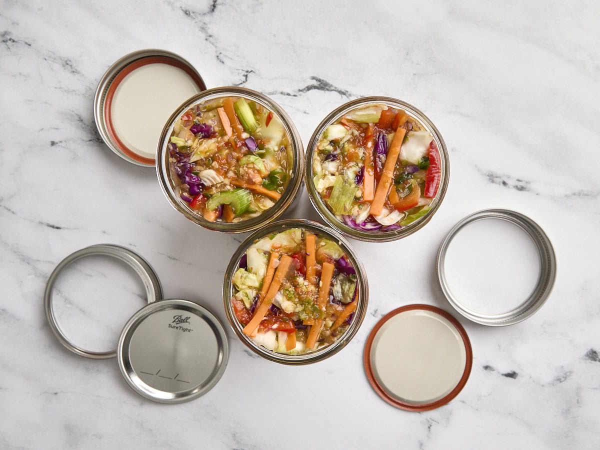 Three jars of homemade fermented vegetables before fermentation.
