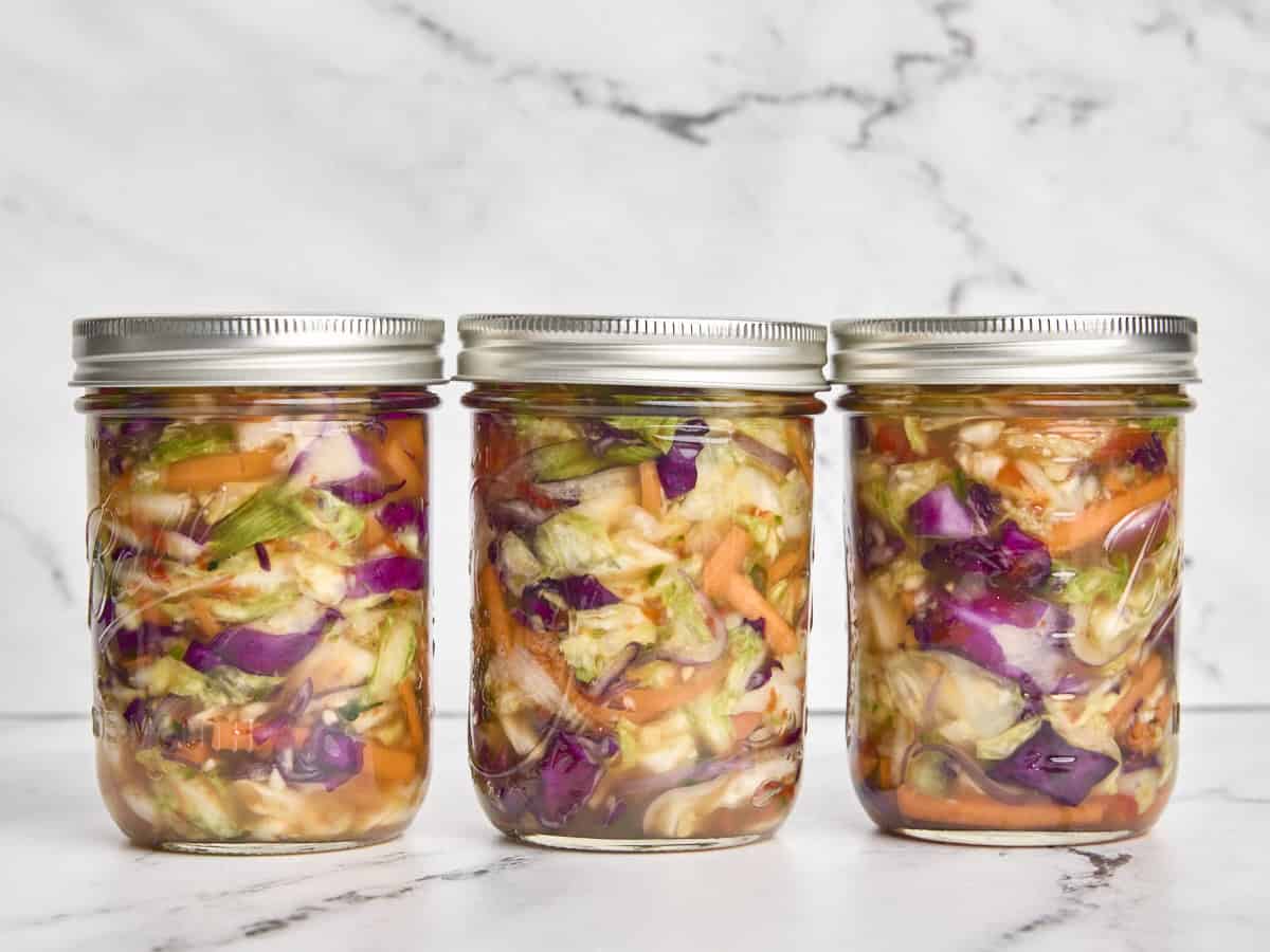 Lids added to three jars of fermented veggies.