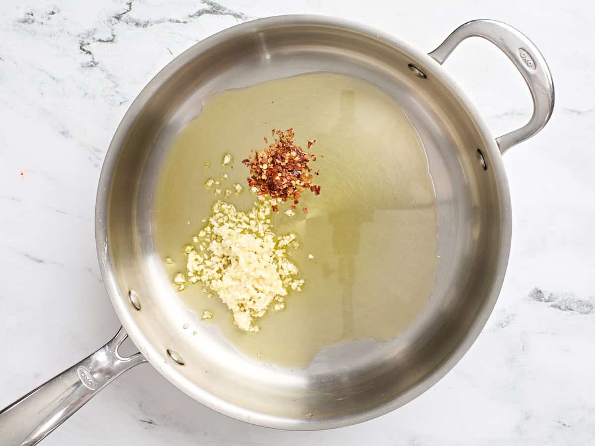 Minced garlic and crushed red pepper flakes in a skillet.
