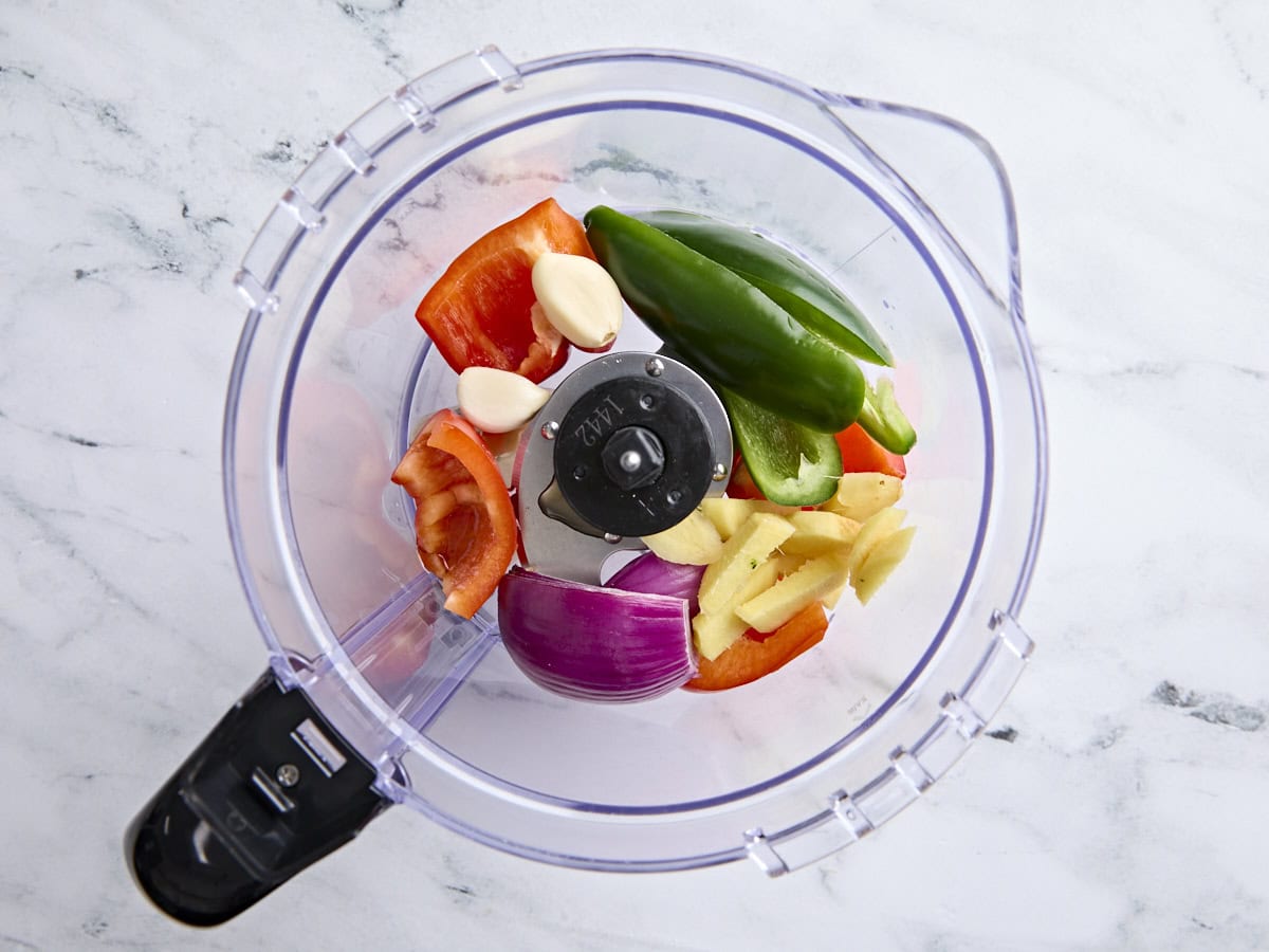 Jalapeno, red bell pepper, red onion, ginger, and garlic in a food processor.