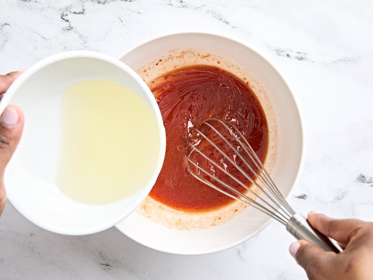 Vegetable oil being whisked into the ingredients for homemade French dressing.