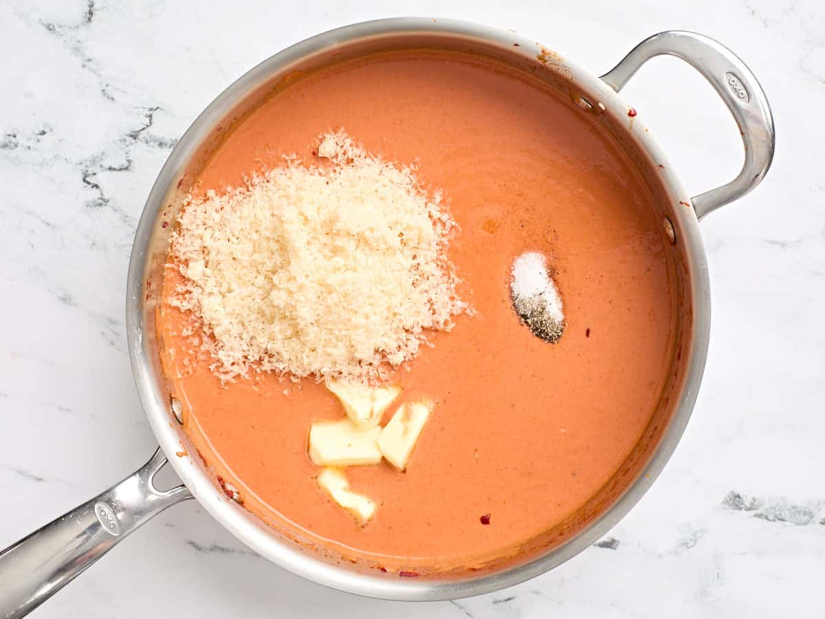 Shredded parmesan, butter, salt, and pepper added to a skillet of homemade vodka sauce.