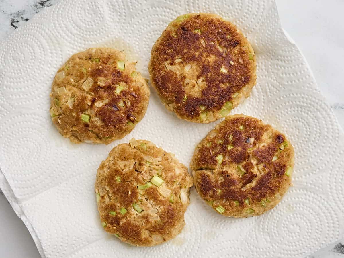 Finished crab cakes on a piece of parchment paper.