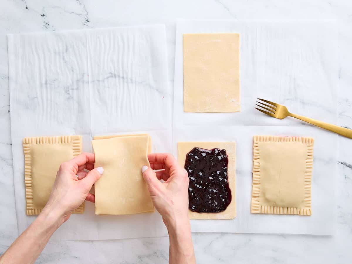 Hands adding the top crust to a homemade pop tart.