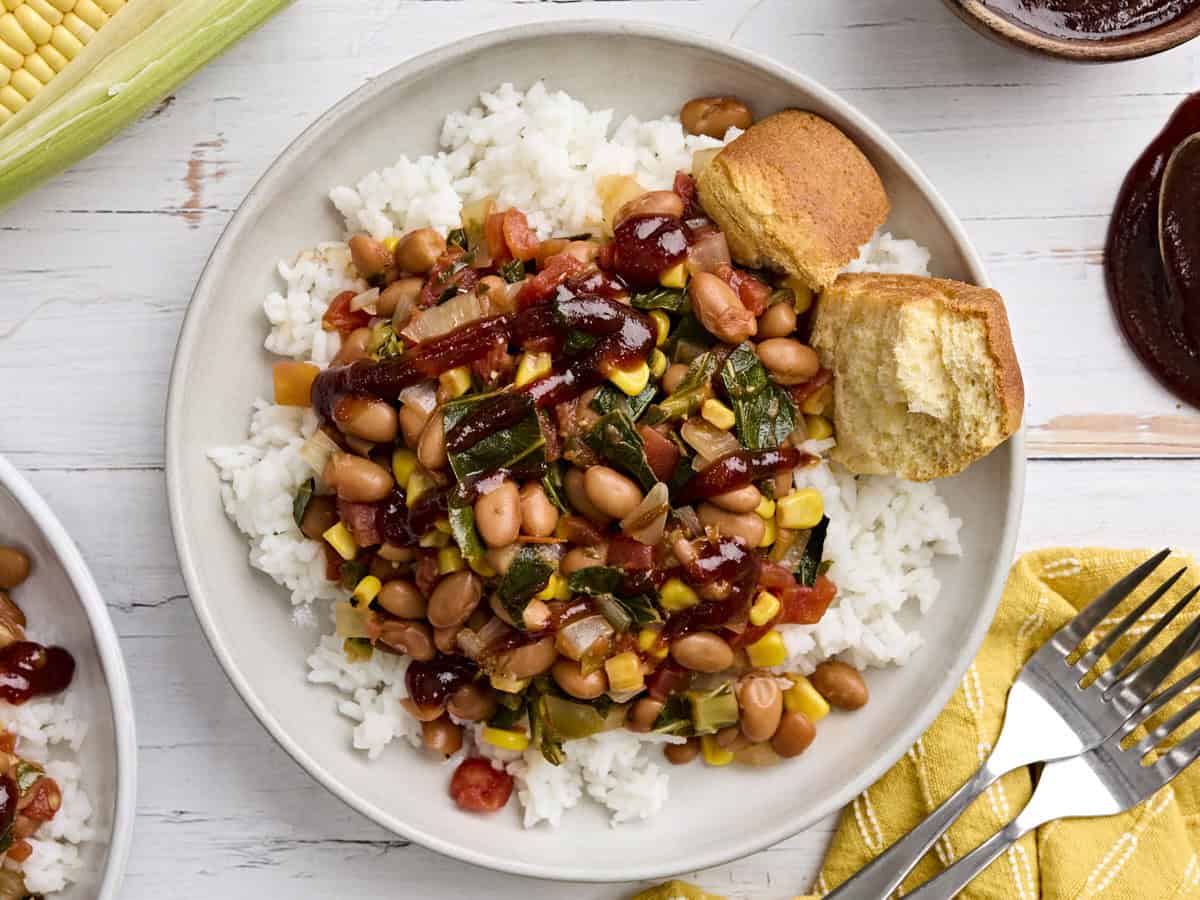 Overhead view of a plate of bbq beans and greens with rice.