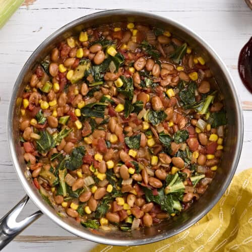 Overhead view of a skillet of bbq beans and greens.