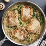 Overhead view of creamy pork chops in a skillet.