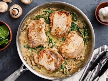 Overhead view of creamy pork chops in a skillet.