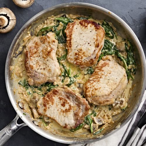 Overhead view of creamy pork chops in a skillet.