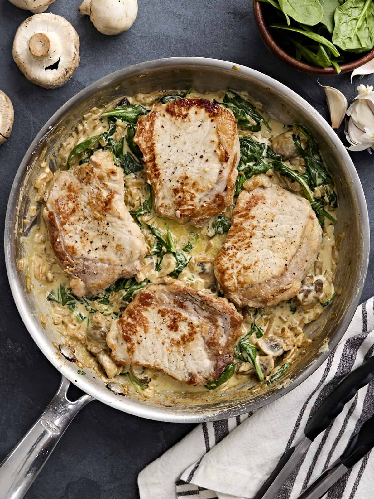 Overhead view of creamy pork chops in a skillet.