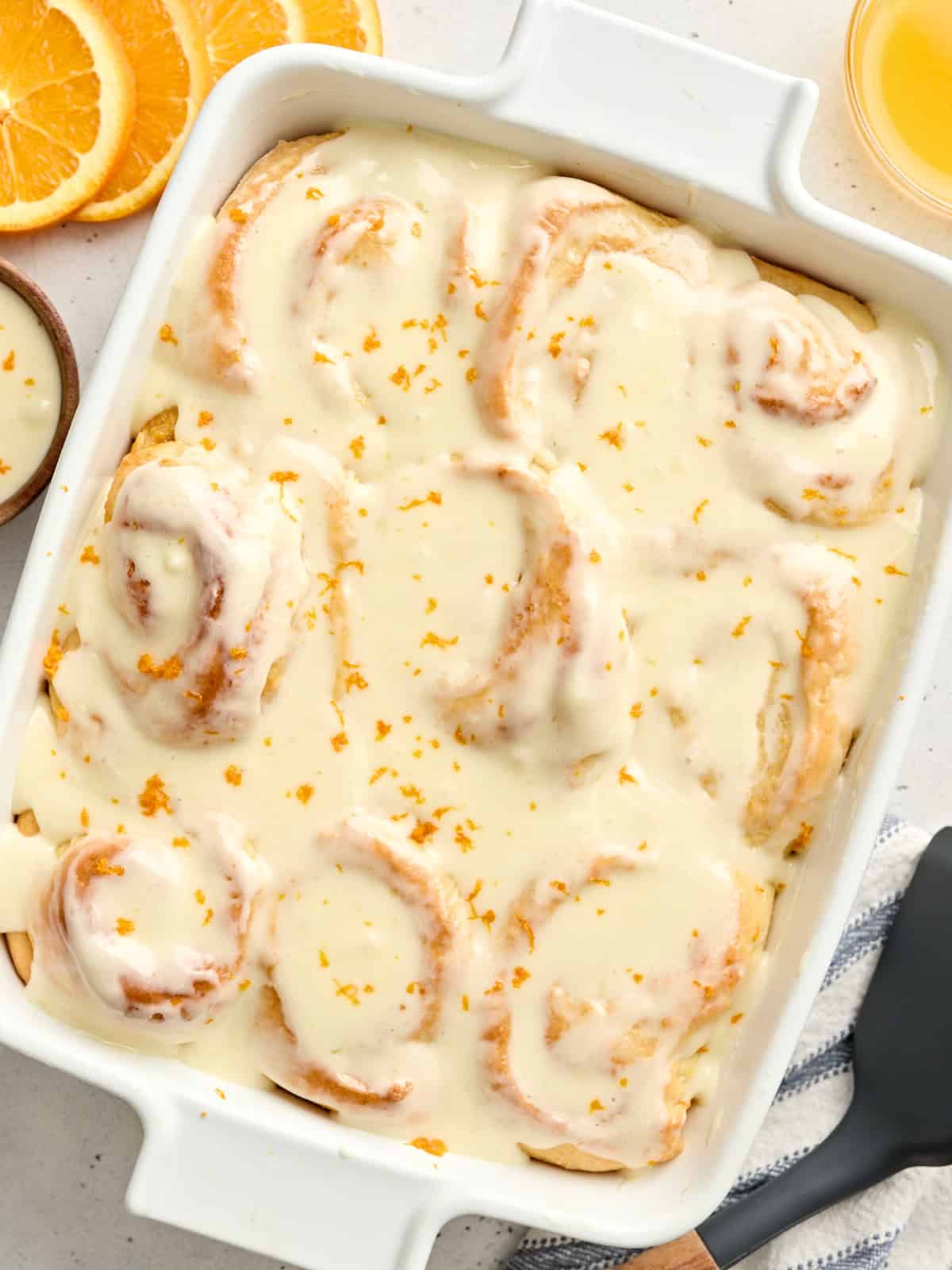Overhead view of homemade orange rolls in a baking dish.