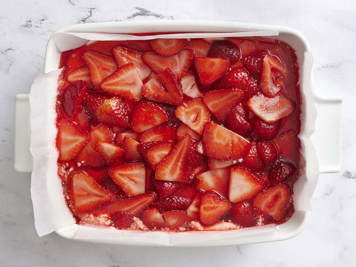 Strawberry jello salad in a baking dish before chilling.