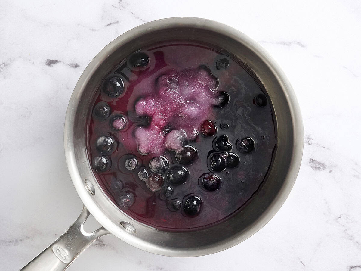 Blueberries and sugar in a sauce pot.