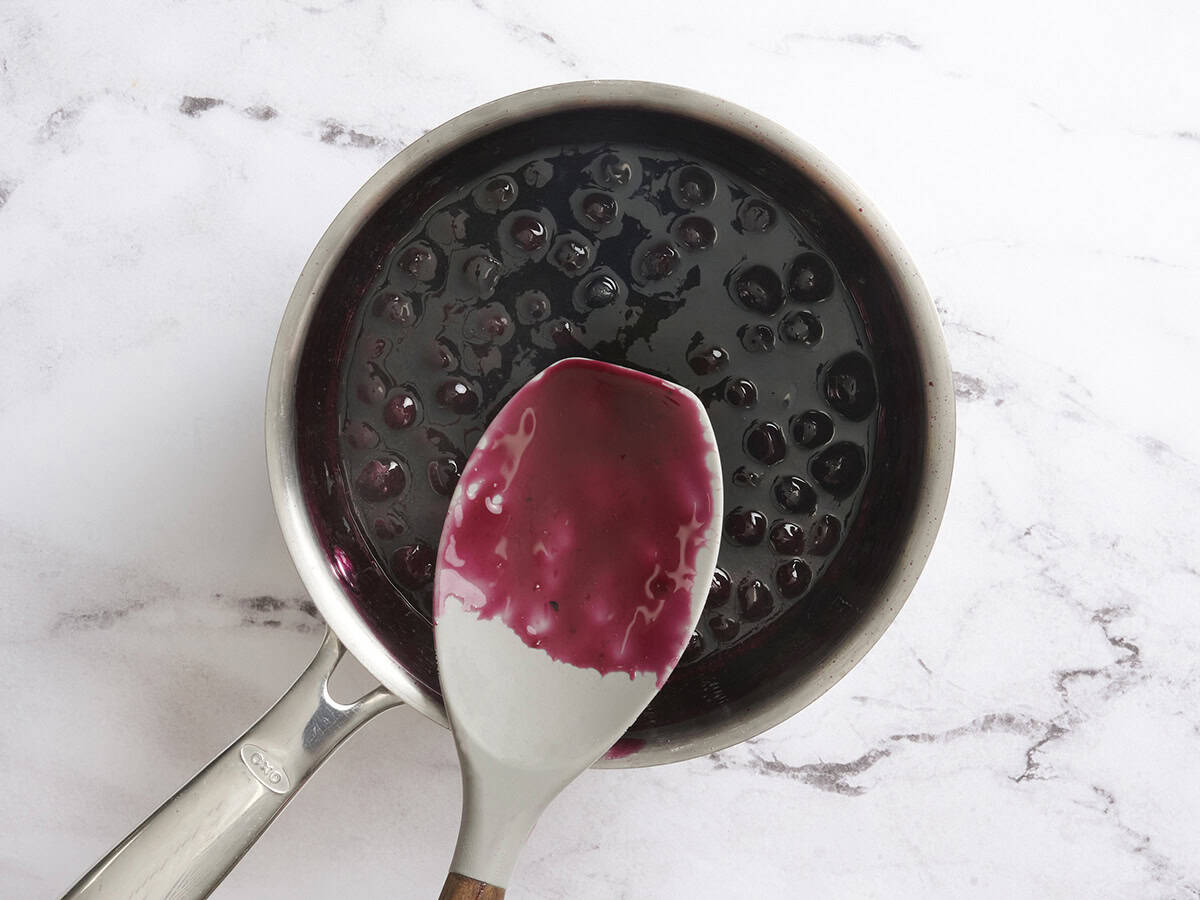 Finished blueberry sauce coating the back of a spoon.