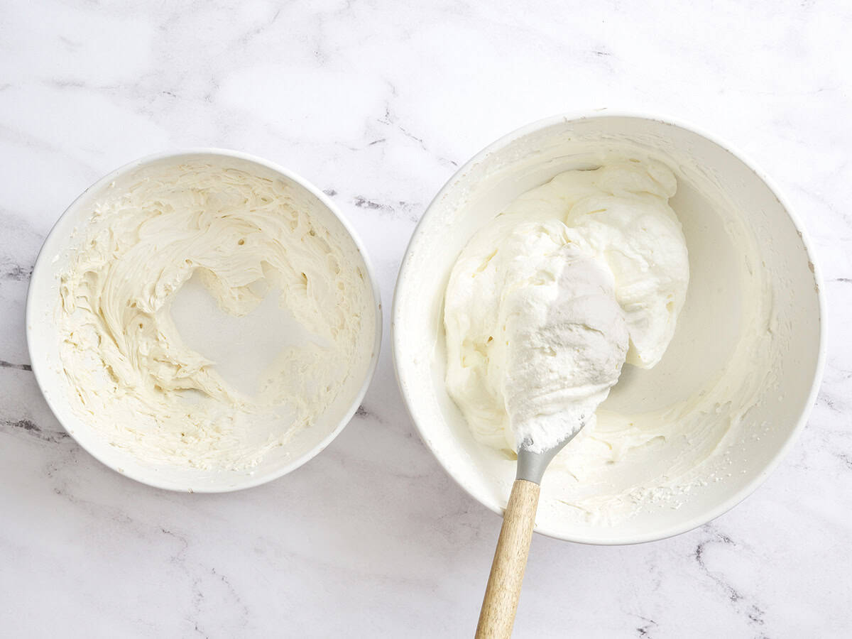 Cream cheese mix and whipped cream being combined in a bowl.