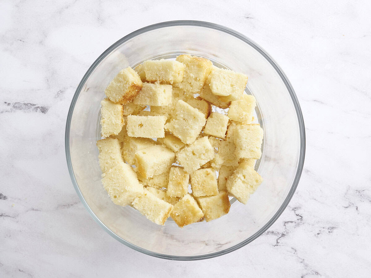 Vanilla cake cubes in the bottom of a trifle dish.