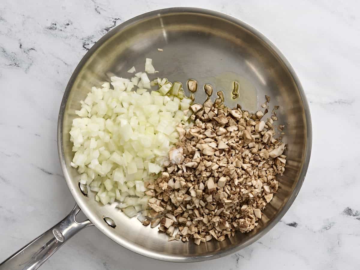 Diced mushrooms and onions in a skillet.