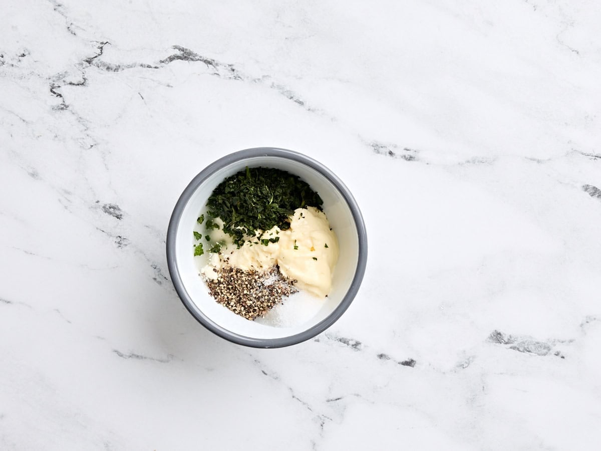 Mayonnaise, basil, white vinegar, salt and pepper in a small mixing bowl.