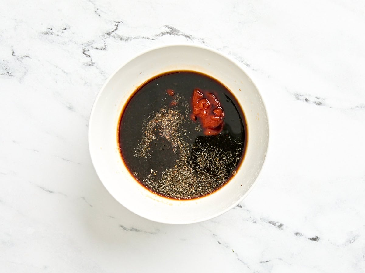 Soy sauce, lime juice, hot sauce, sugar, and seasonings in a mixing bowl.