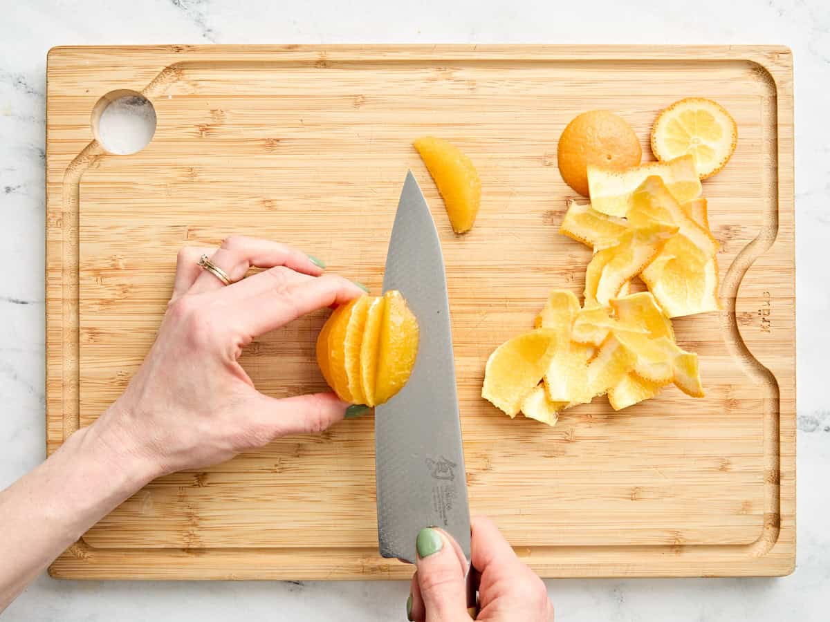 A knife cutting an orange using the supreme method.
