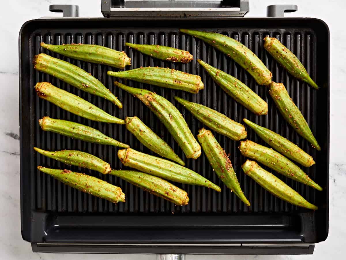 Seasoned okra on a grill.