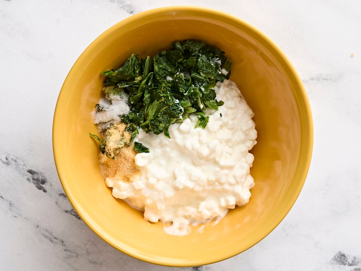 Cottage cheese, chopped thawed spinach and seasonings in a bowl.
