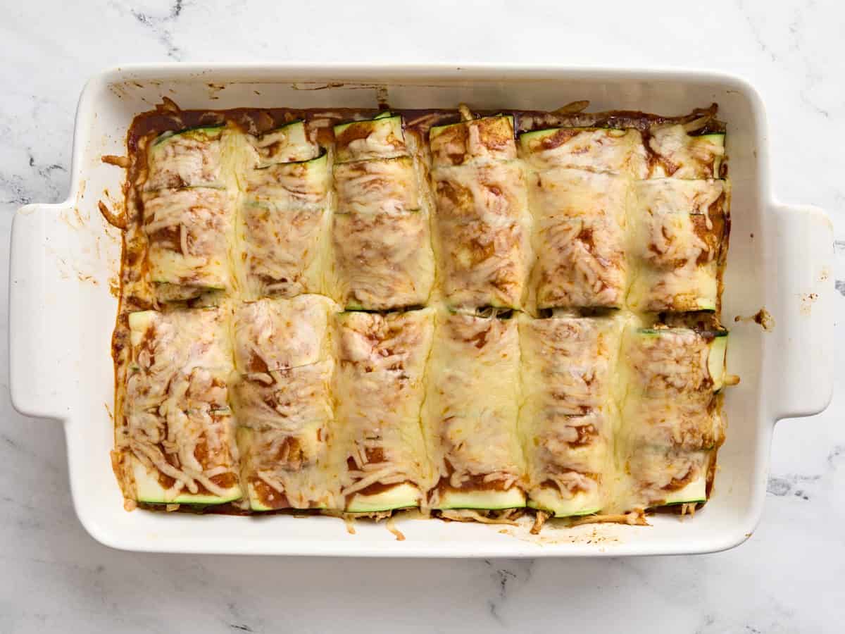 Finished zucchini enchiladas in a baking dish.
