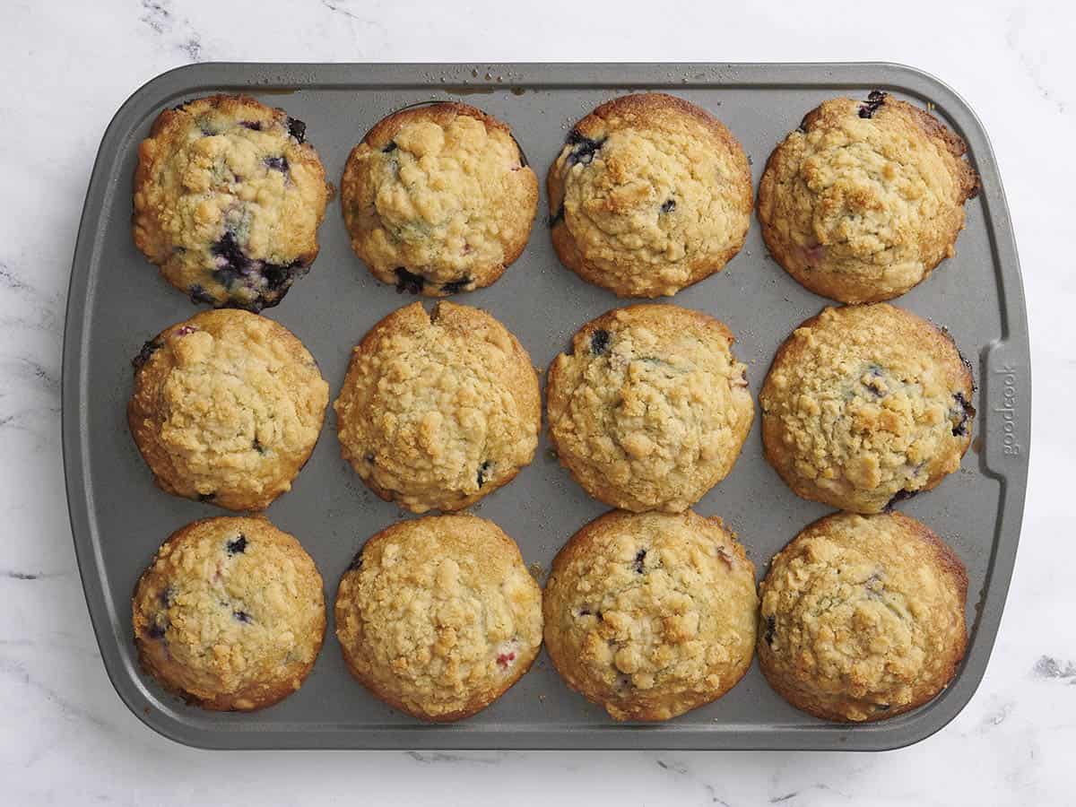 Homemade blueberry and rhubarb muffins in a muffin pan.
