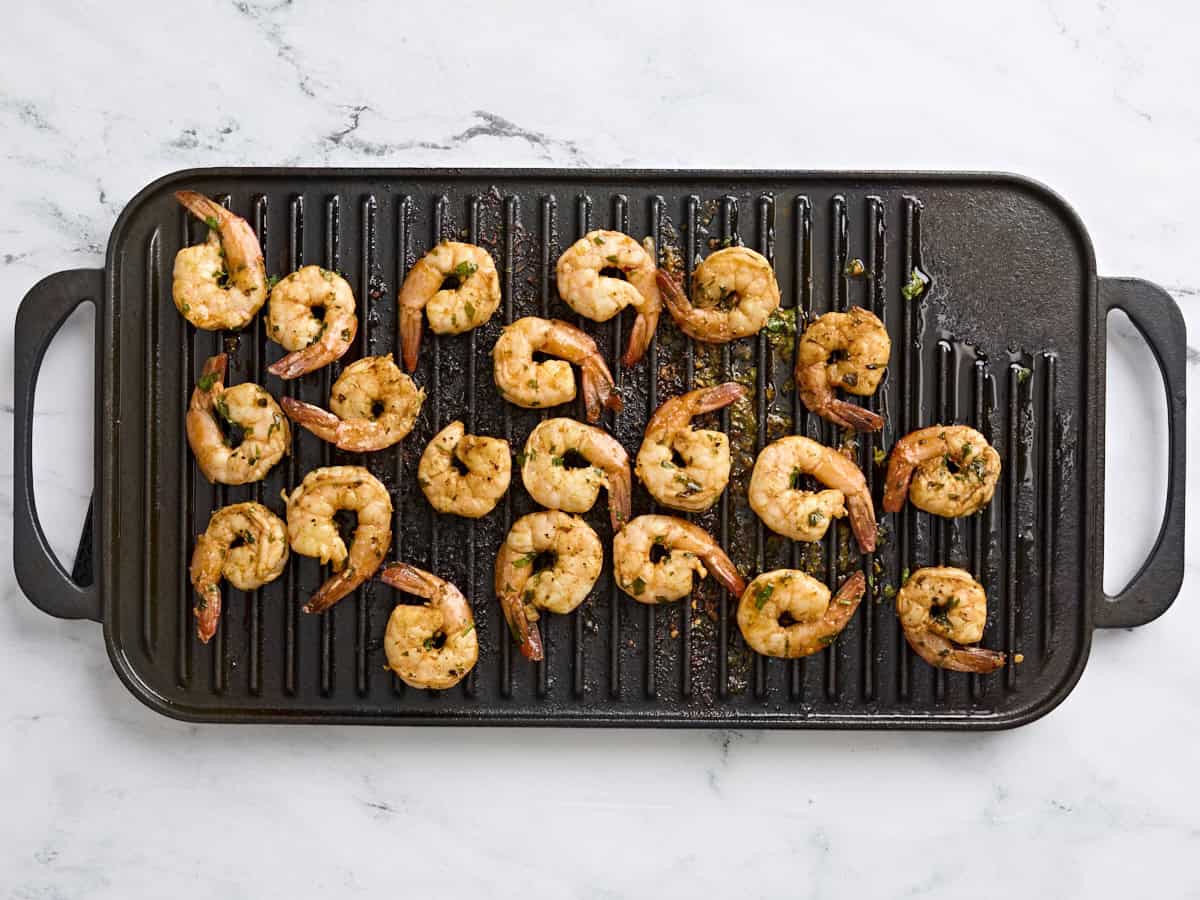 Cooked grilled shrimp on a grill.