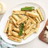 Overhead view of air fried zucchini on a plate.