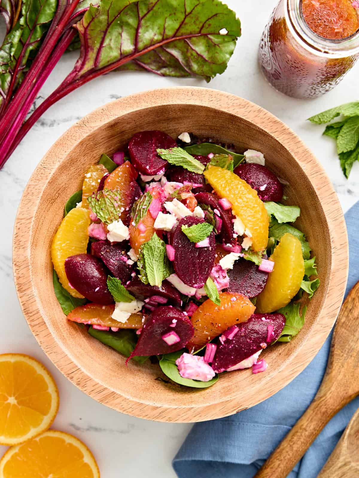 Overhead view of an orange and beet salad in a bowl.