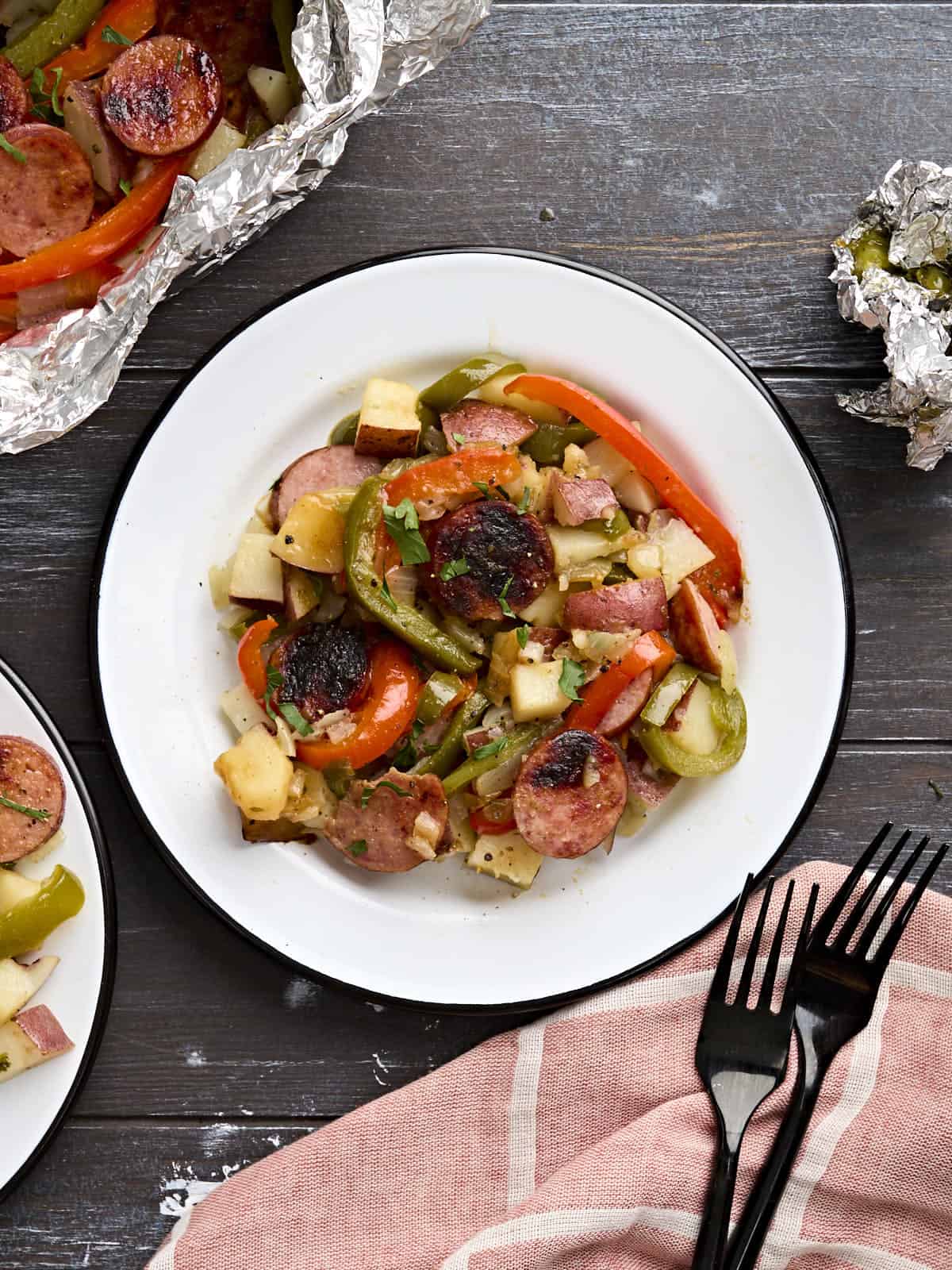Overhead view of a plate of grilled sausages and peppers.