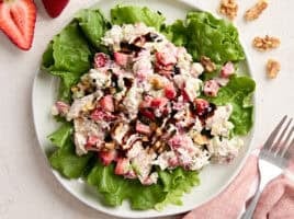 Overhead view of a strawberry chicken salad on a bed of greens.