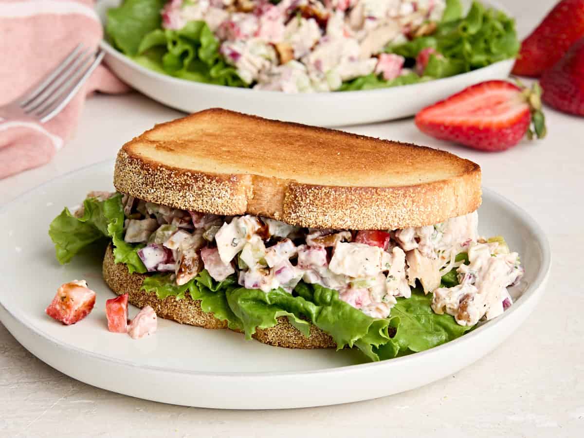 A strawberry chicken salad sandwich on a plate.
