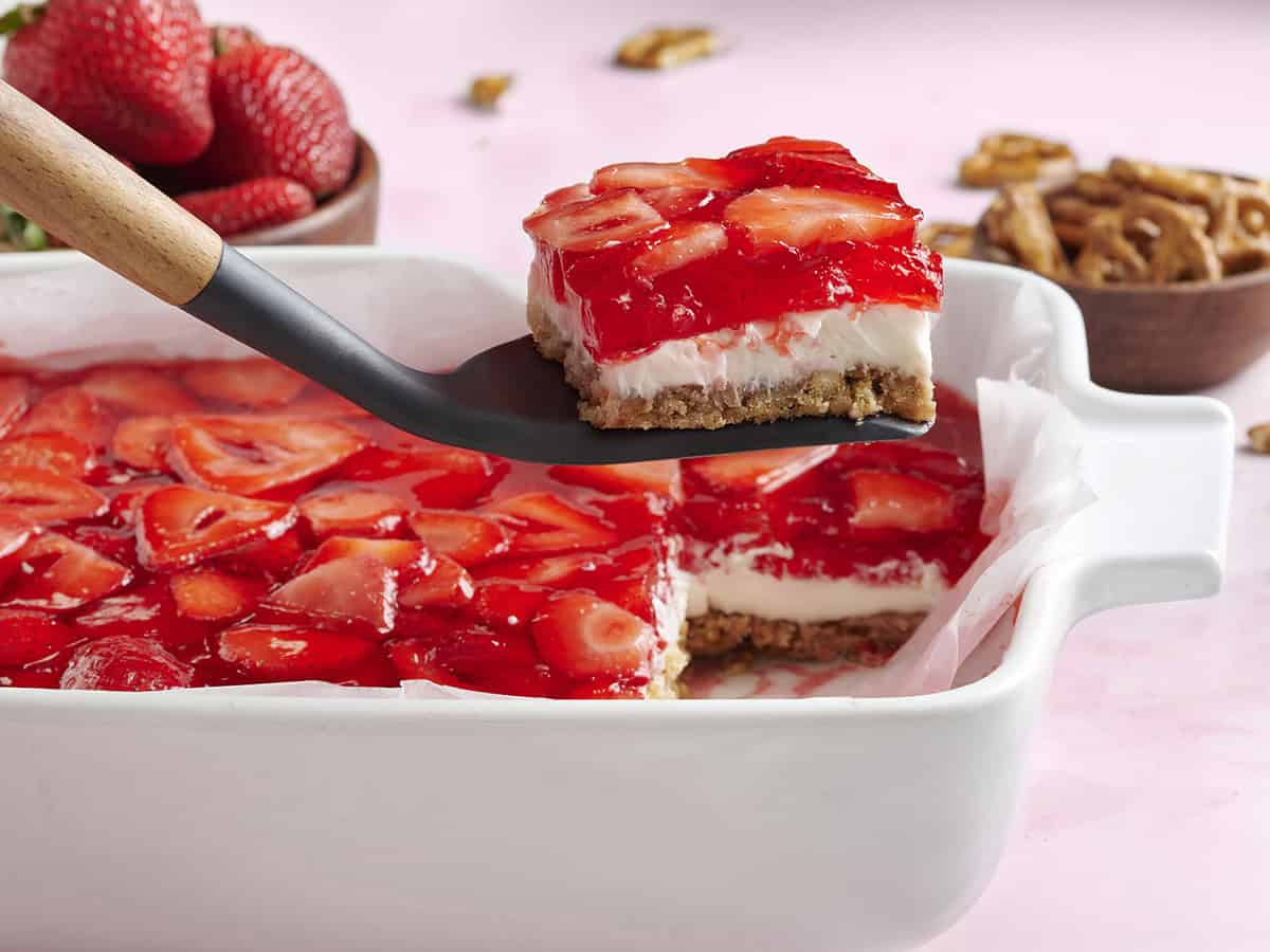 Strawberry pretzel salad in a baking dish with a slice being taken.