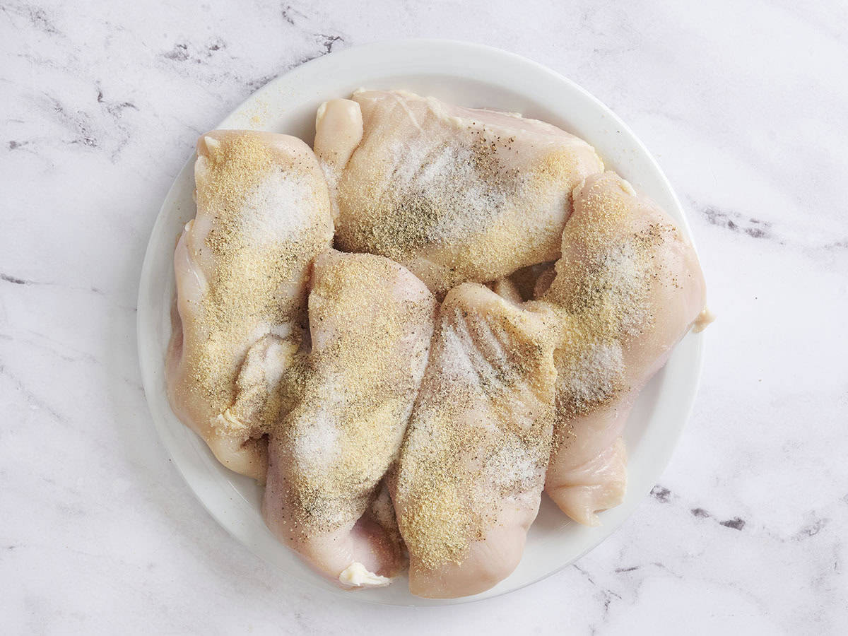 Seasoned chicken breasts on a plate.