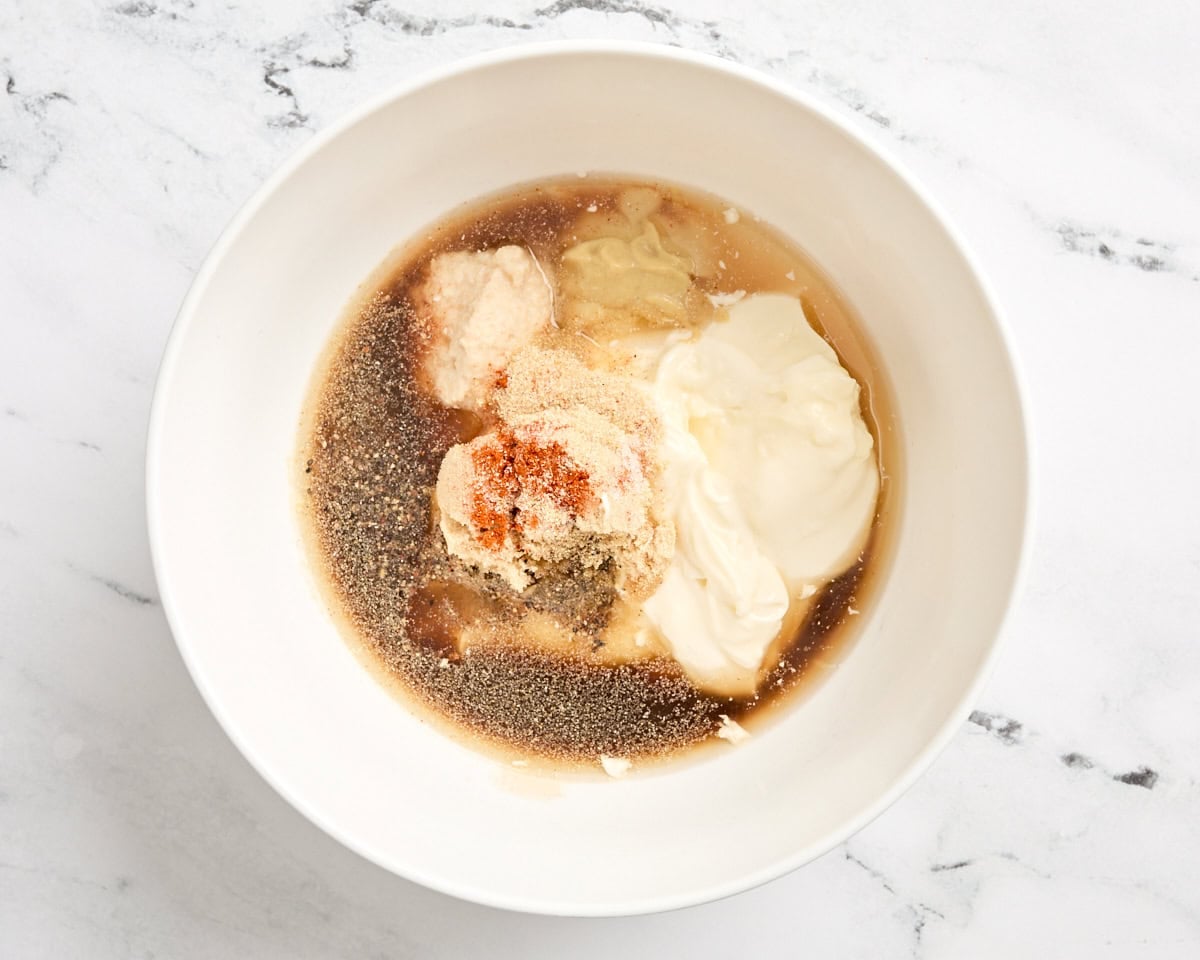 The ingredients for alabama white sauce in a mixing bowl before mixing.