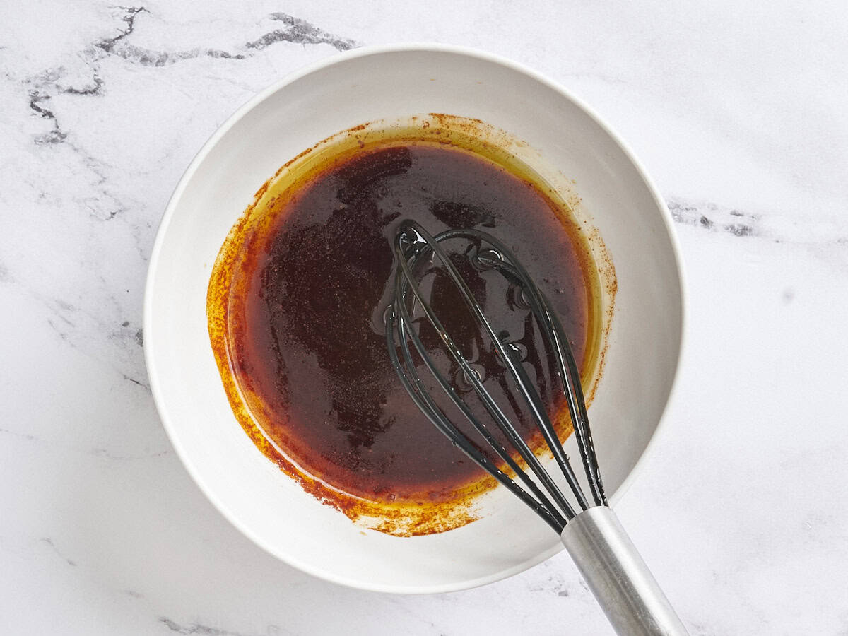 Grilled mushroom kebab marinade being whisked in a bowl.