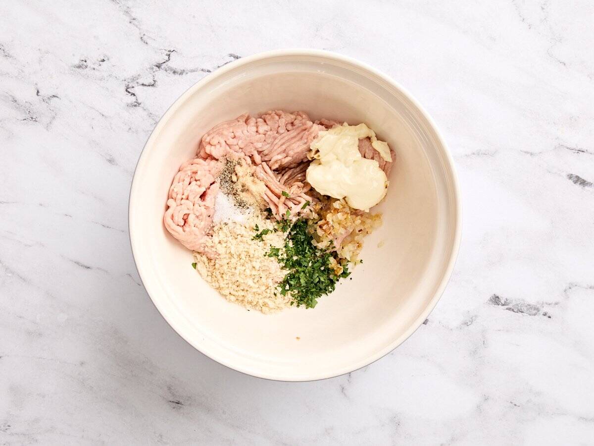 The ingredients for chicken burgers in a bowl.