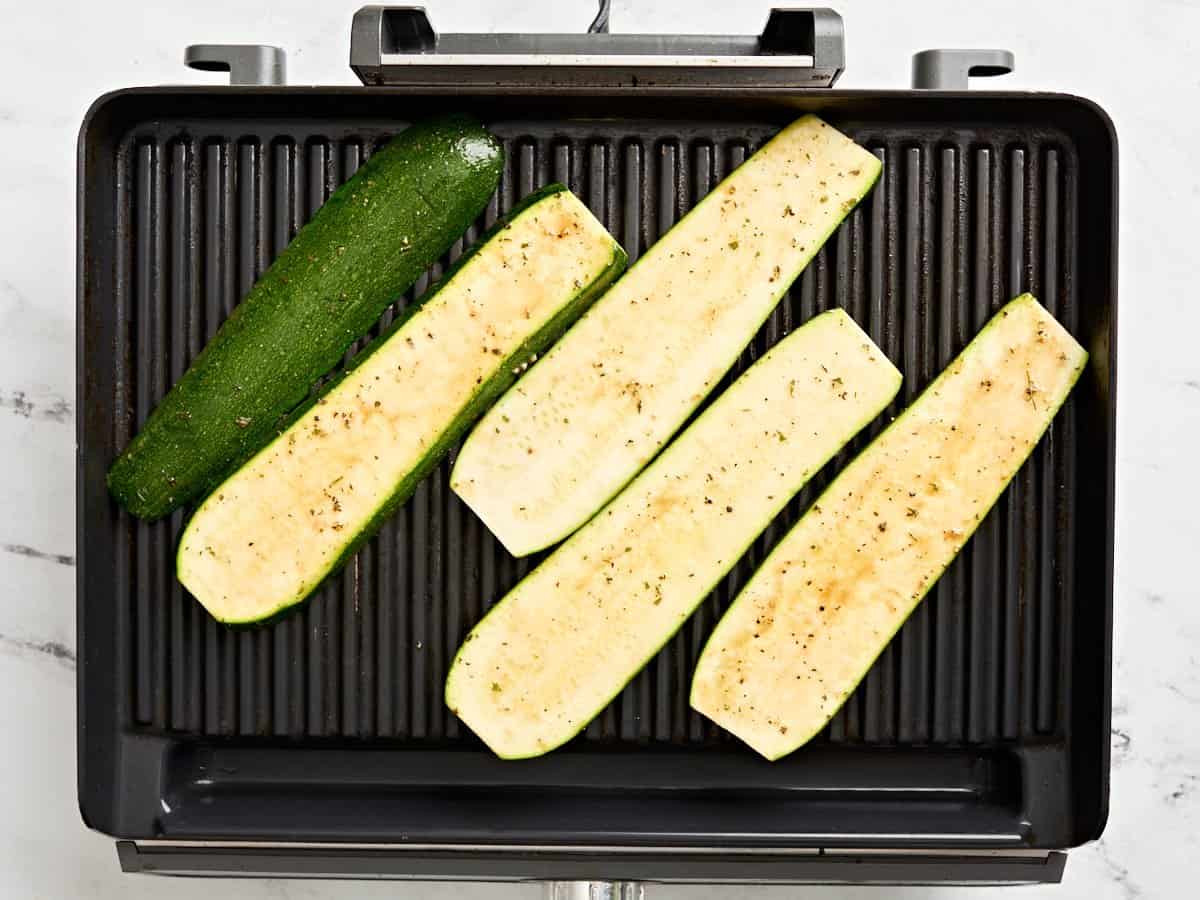 Zucchini slices on a grill.