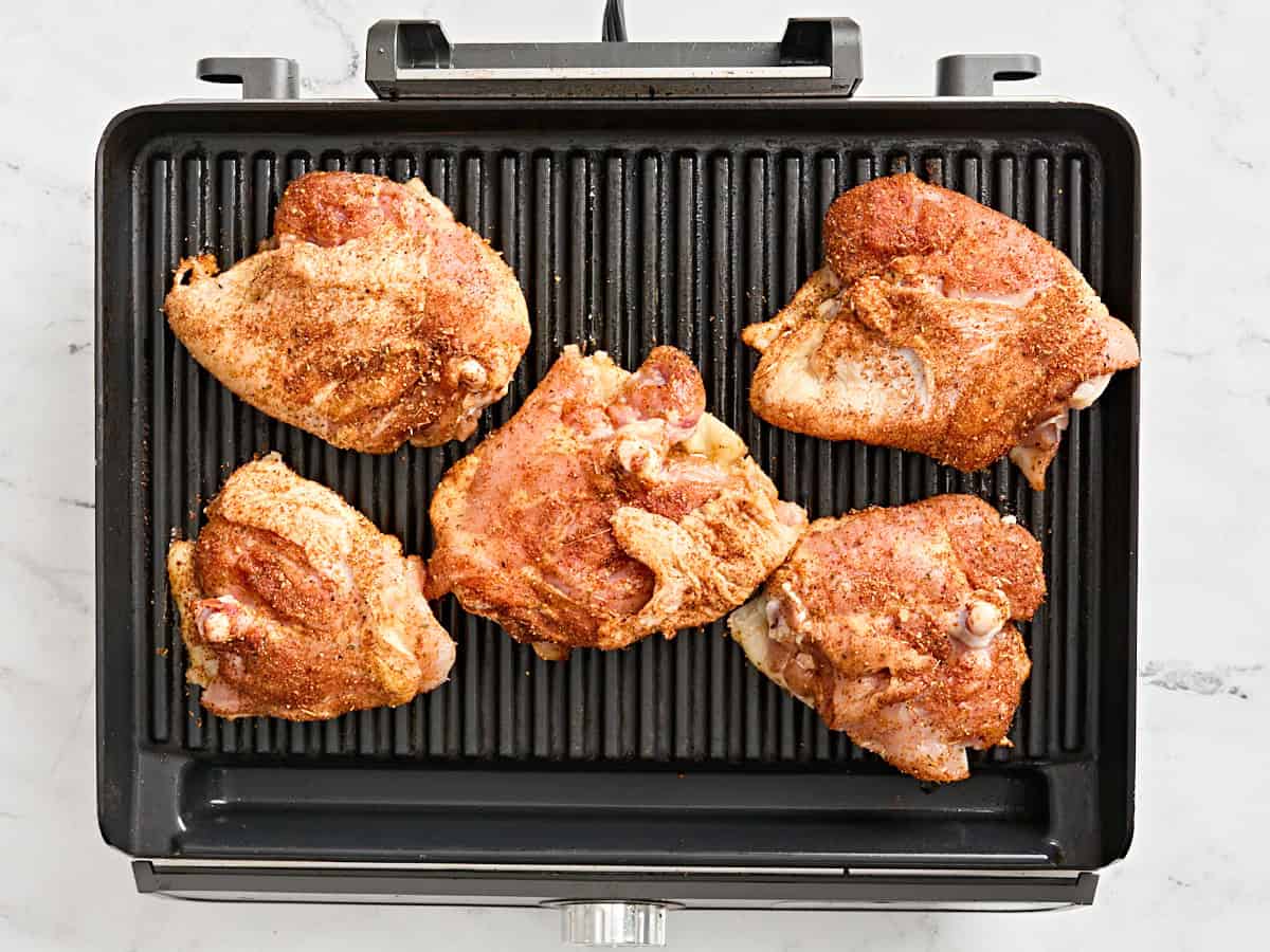 Dry rubbed thighs on a grill.