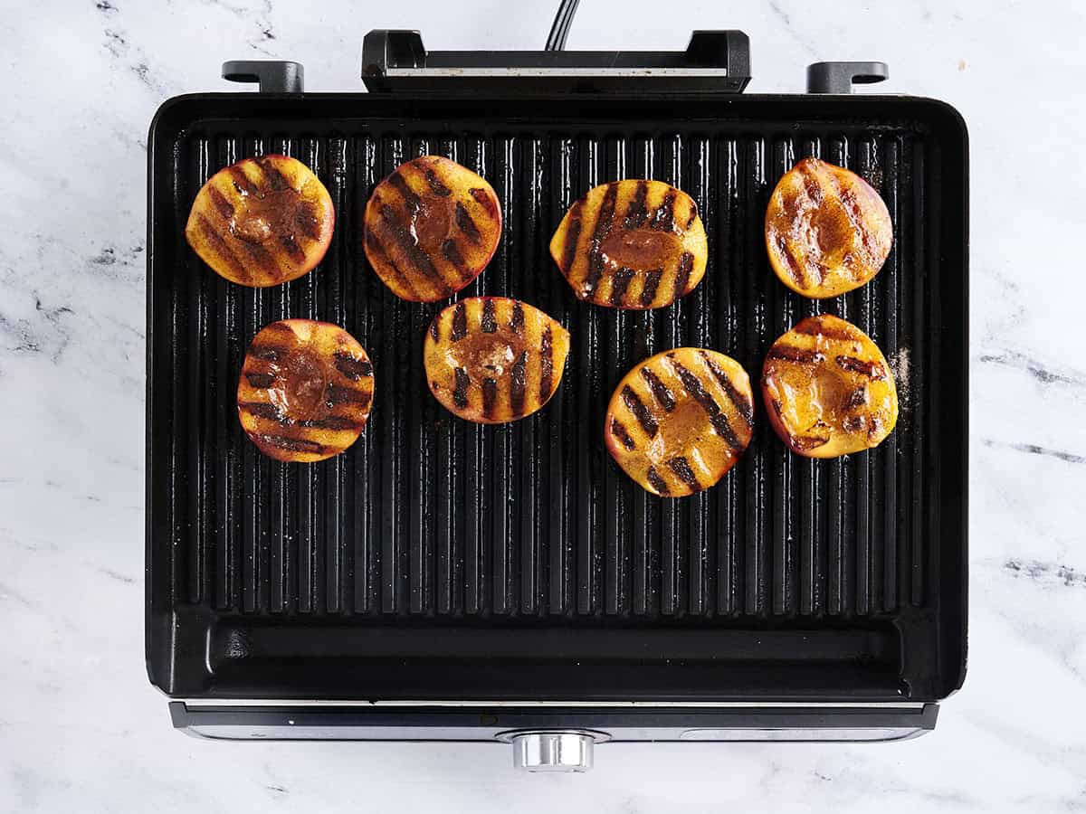 Grilled peaches on a grill.