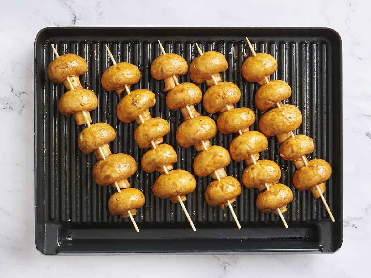 Grilled mushroom skewers on a grill.