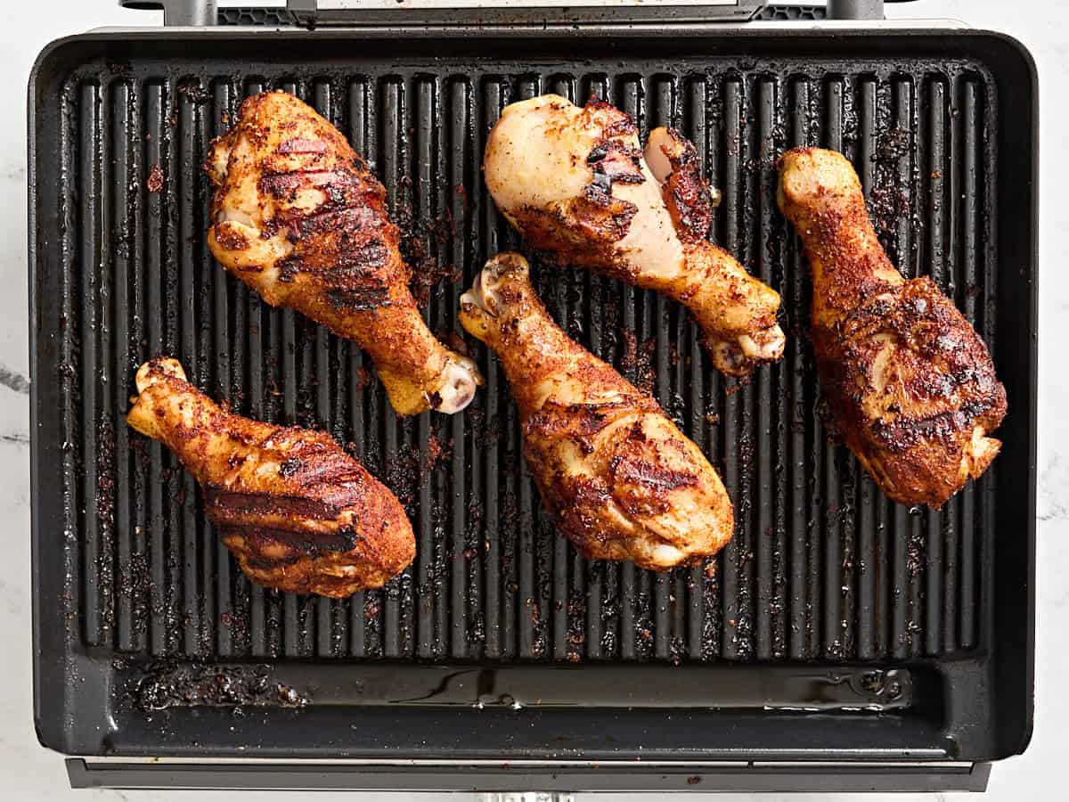 Grilled chicken drumsticks on a grill.