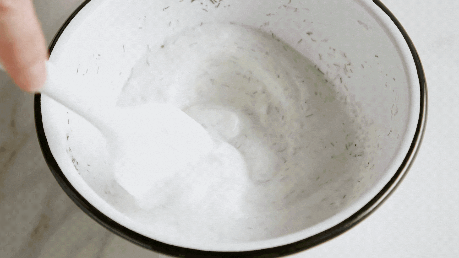 Sliced cucumber and red onion on a cutting board.